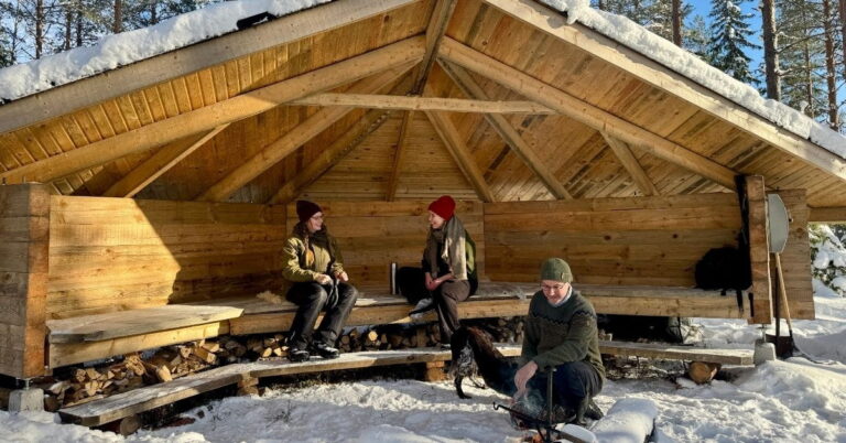 Kuvassa kaksi naista ja mies laavulla.