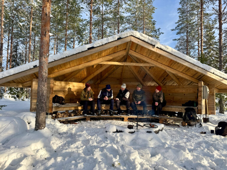 Ulkoilijoita istumassa LockCornerin laavulla
