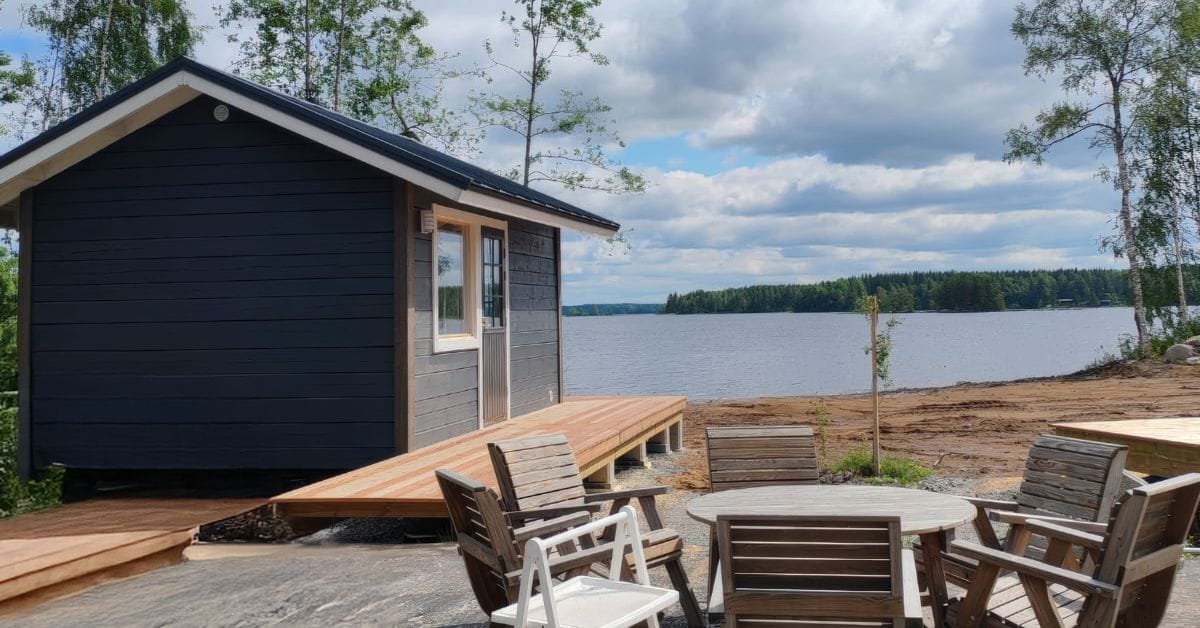 Moderni saunamökki rantatontilla järven äärellä.